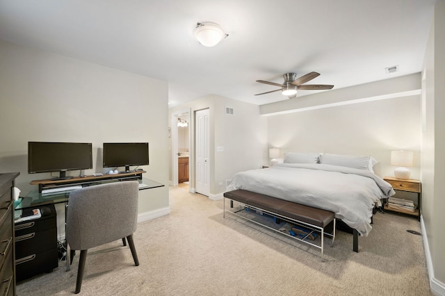 carpeted bedroom featuring a desk, baseboards, ceiling fan, and ensuite bath