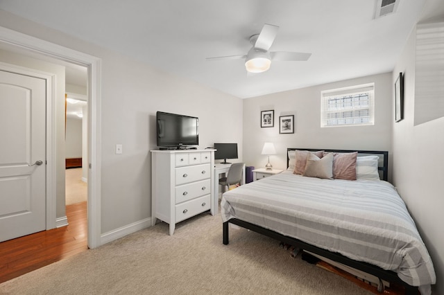 bedroom featuring a ceiling fan, light colored carpet, and baseboards