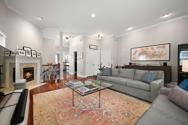 living room with wood finished floors, crown molding, recessed lighting, a fireplace, and baseboards