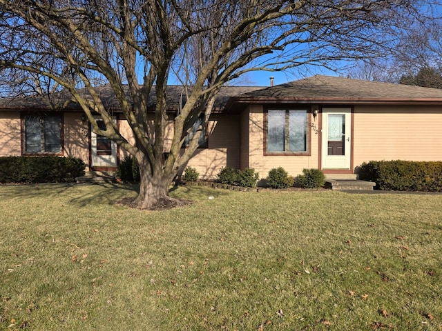 single story home featuring roof with shingles and a front lawn