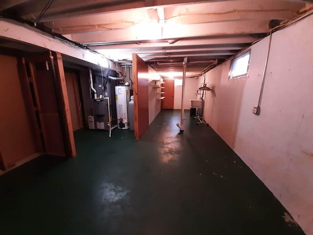 basement with heating unit, water heater, and a sink