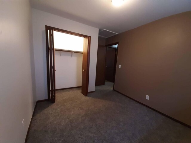 unfurnished bedroom featuring a closet, baseboards, and carpet