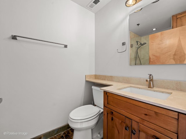 full bathroom featuring visible vents, vanity, toilet, baseboards, and tiled shower