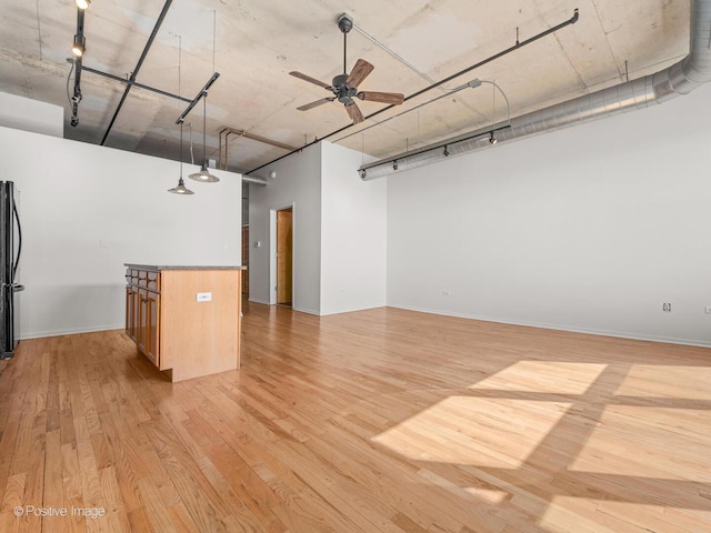 interior space with light wood-style floors, ceiling fan, and rail lighting