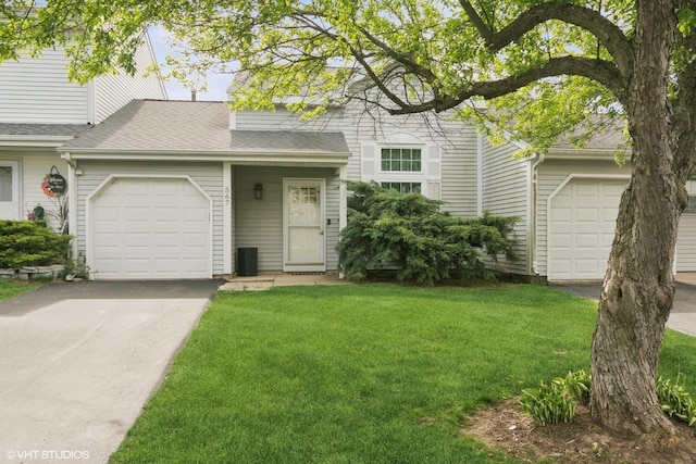 view of front facade with a garage, a shingled roof, a front yard, and aphalt driveway
