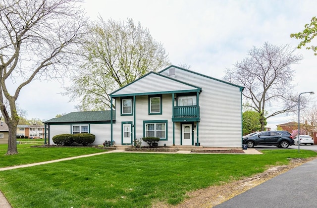 view of front facade with a front lawn and a balcony