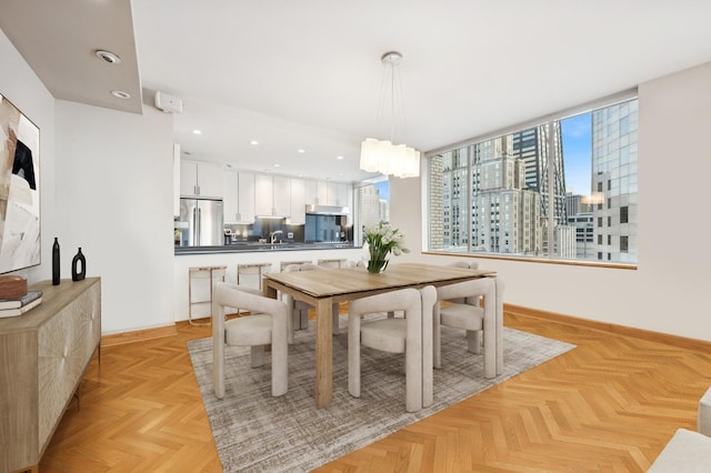dining space featuring a view of city, recessed lighting, baseboards, and an inviting chandelier