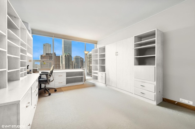 office space with a view of city, carpet flooring, and built in desk