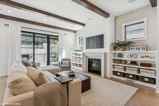 1934 W Patterson Ave, Chicago, IL 60613 - living area with wood finished floors, a glass covered fireplace, beam ceiling, and recessed lighting