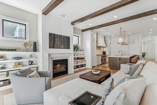 1934 W Patterson Ave, Chicago, IL 60613 - living area featuring beamed ceiling, recessed lighting, light wood-type flooring, a glass covered fireplace, and built in shelves