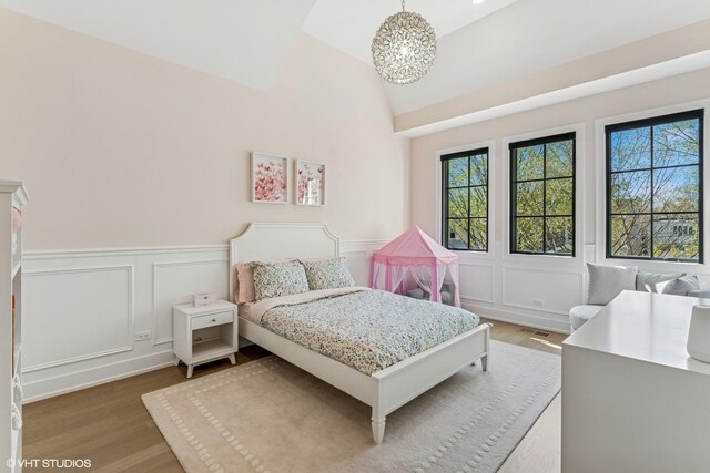 1934 W Patterson Ave, Chicago, IL 60613 - bedroom featuring wood finished floors, a decorative wall, a chandelier, a wainscoted wall, and vaulted ceiling