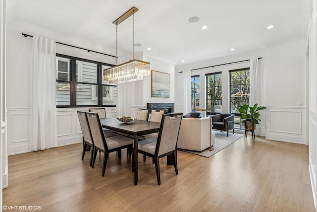 1934 W Patterson Ave, Chicago, IL 60613 - dining room featuring a decorative wall, crown molding, light wood-type flooring, a chandelier, and a wainscoted wall