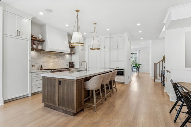 1934 W Patterson Ave, Chicago, IL 60613 - kitchen featuring open shelves, decorative backsplash, a breakfast bar, light wood-style flooring, and recessed lighting