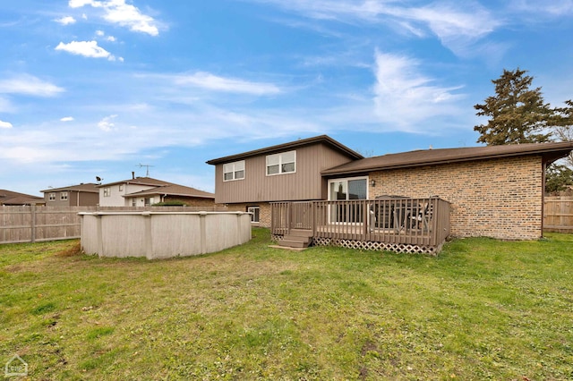710 E 194th St, Glenwood, IL 60425 - back of property featuring fence, brick siding, a deck, a fenced in pool, and a lawn