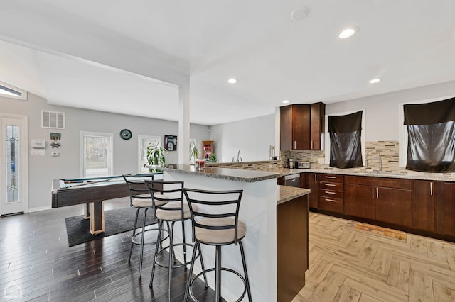 710 E 194th St, Glenwood, IL 60425 - kitchen featuring decorative backsplash, a kitchen bar, visible vents, a sink, and light stone counters
