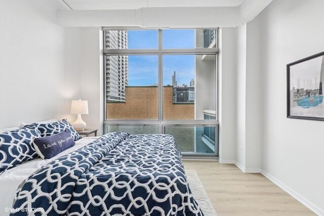 bedroom featuring baseboards and wood finished floors