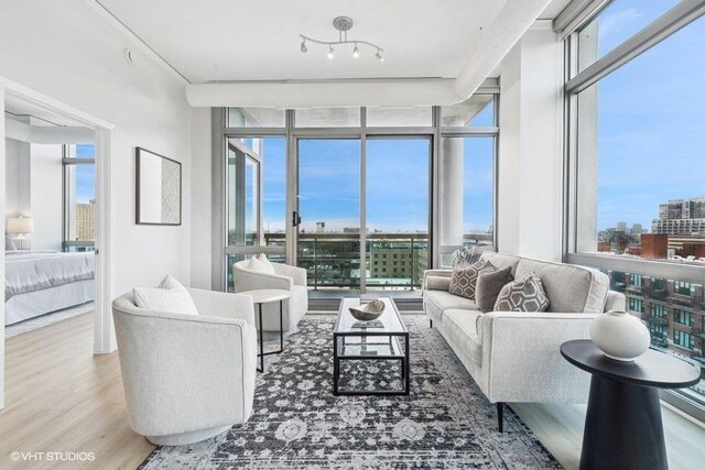 living area featuring a wall of windows, a view of city, and wood finished floors