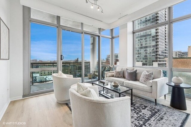 living room with expansive windows, baseboards, and wood finished floors