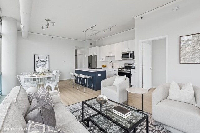 living room with track lighting and light wood-type flooring