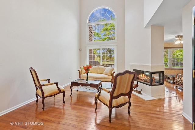 1537 Aberdeen Ct Unit 67, Naperville, IL 60564 - living area with light wood-style flooring, a high ceiling, a fireplace, baseboards, and ceiling fan