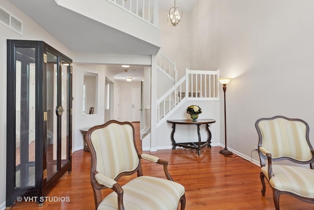1537 Aberdeen Ct Unit 67, Naperville, IL 60564 - sitting room featuring wood finished floors, baseboards, visible vents, stairway, and a notable chandelier