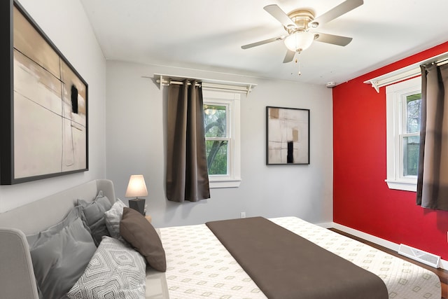 bedroom with multiple windows, a ceiling fan, and baseboards