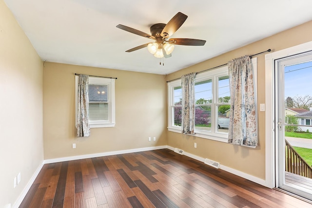 unfurnished room with dark wood-style floors, ceiling fan, and baseboards