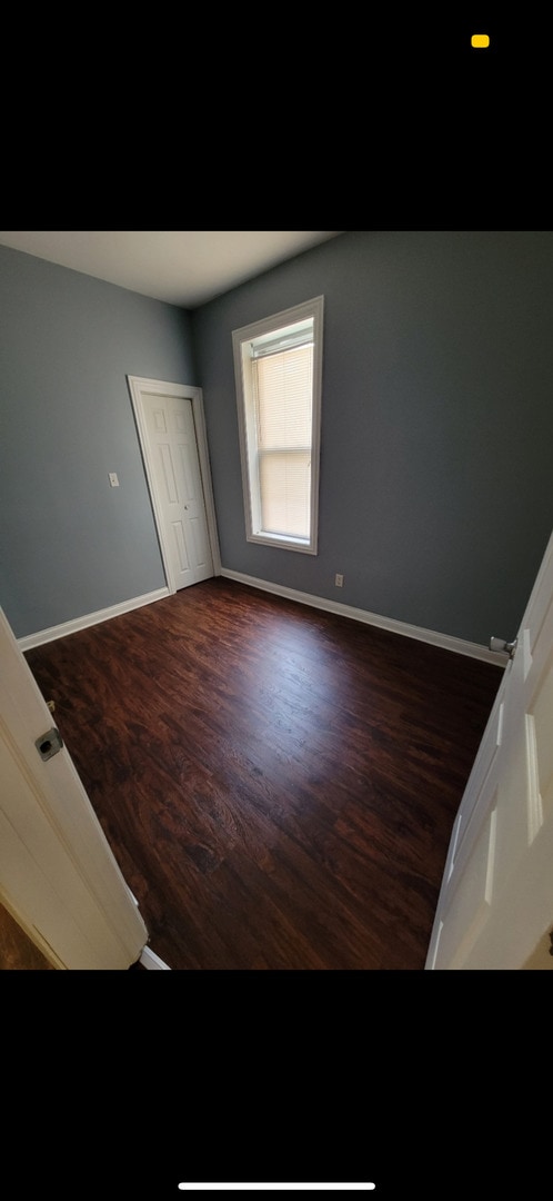 3824 W Grenshaw St, Chicago, IL 60624 - unfurnished bedroom featuring dark wood-style floors and baseboards