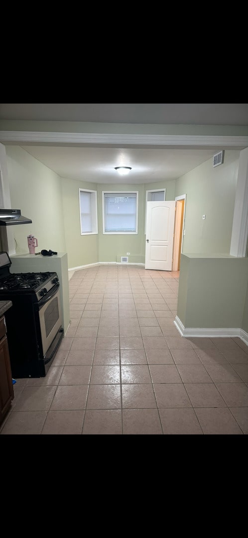 3824 W Grenshaw St, Chicago, IL 60624 - kitchen with gas stove, light tile patterned floors, and baseboards