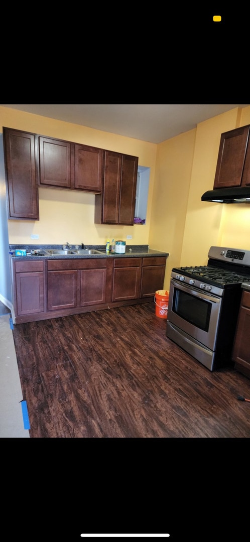 3824 W Grenshaw St, Chicago, IL 60624 - kitchen with stainless steel gas range, extractor fan, dark wood-type flooring, and dark brown cabinets