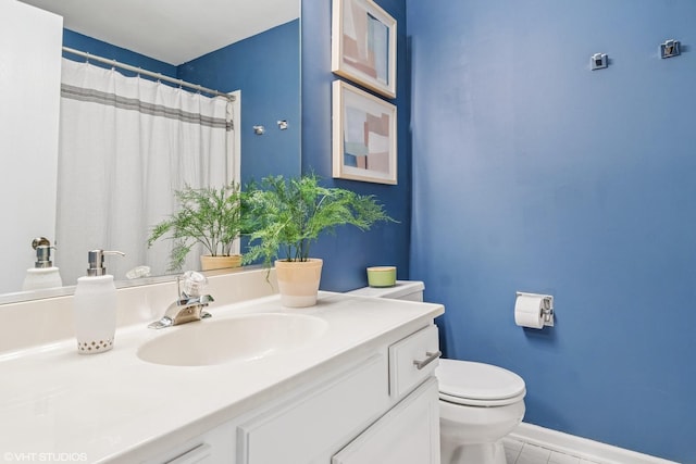 bathroom with vanity, toilet, tile patterned floors, baseboards, and curtained shower