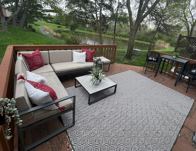 wooden deck featuring a yard, a water view, and an outdoor living space