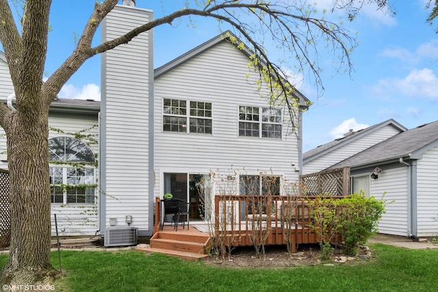 back of house featuring central air condition unit, a deck, a chimney, and a lawn