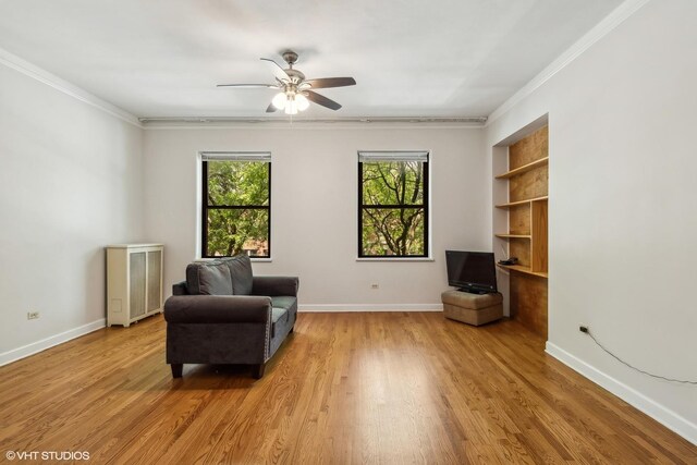sitting room featuring baseboards, ornamental molding, a ceiling fan, and light wood finished floors