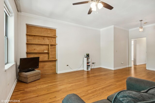 living room with baseboards, ceiling fan, ornamental molding, and wood finished floors