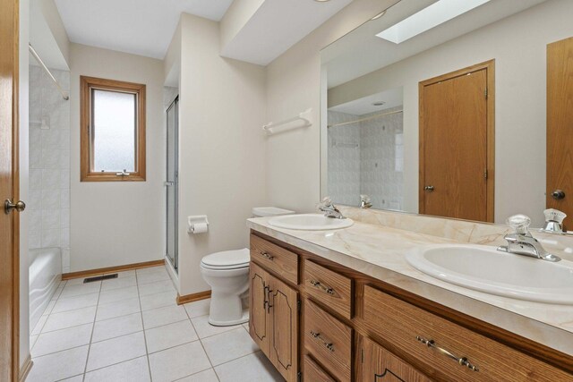 bathroom with a shower with door, visible vents, a sink, and tile patterned floors
