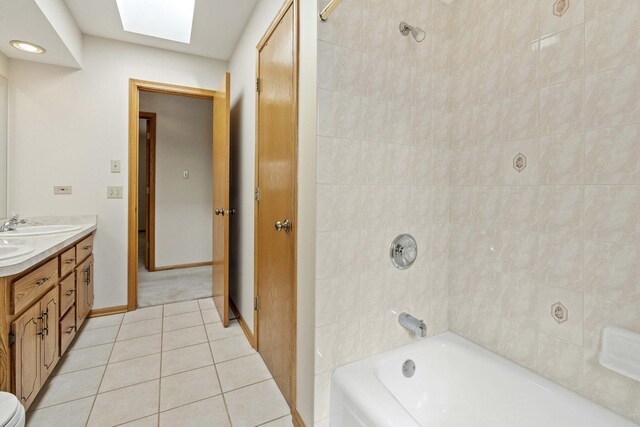 bathroom featuring shower / bath combination, double vanity, a sink, tile patterned floors, and baseboards