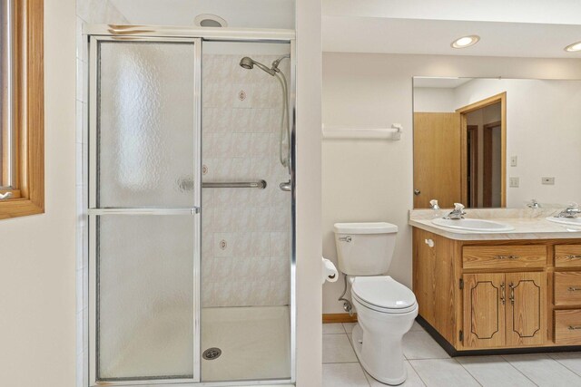 bathroom featuring vanity, tile patterned floors, a shower stall, and toilet
