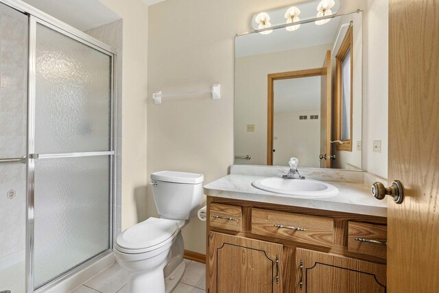 full bathroom with tile patterned flooring, a shower stall, vanity, baseboards, and toilet