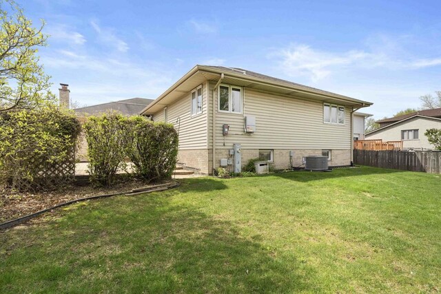 back of house with a lawn, fence, and central air condition unit