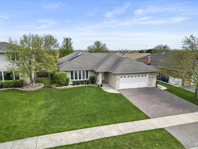 ranch-style home with decorative driveway, an attached garage, a chimney, and a front yard