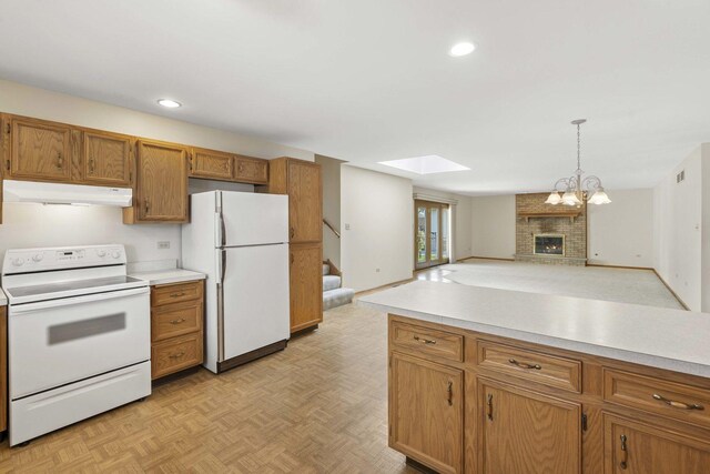 kitchen featuring brown cabinetry, a skylight, light countertops, under cabinet range hood, and white appliances