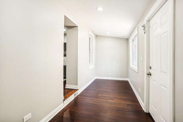 hallway featuring recessed lighting, baseboards, and dark wood-style floors