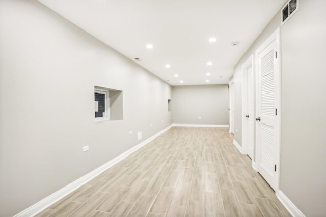below grade area featuring light wood-style floors, baseboards, recessed lighting, and visible vents