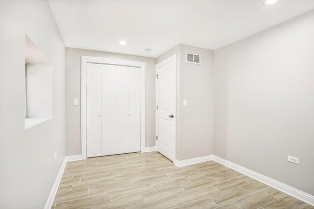 unfurnished bedroom featuring visible vents, a closet, baseboards, light wood-style floors, and recessed lighting