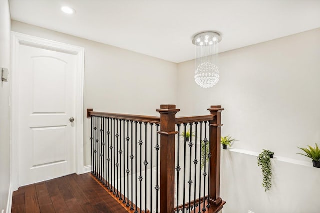 hall with a notable chandelier, recessed lighting, baseboards, an upstairs landing, and dark wood-style floors