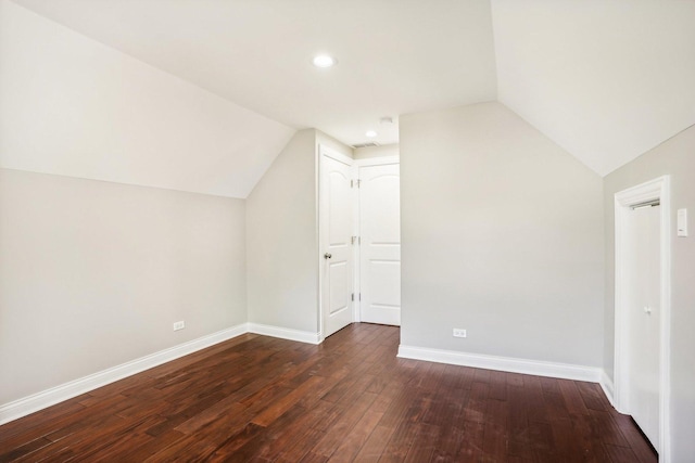 additional living space with dark wood-type flooring, recessed lighting, baseboards, and lofted ceiling