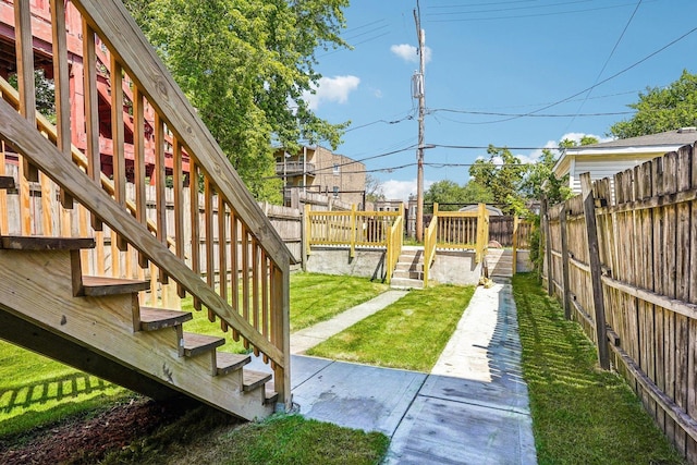 view of yard featuring a fenced backyard, a wooden deck, and stairway