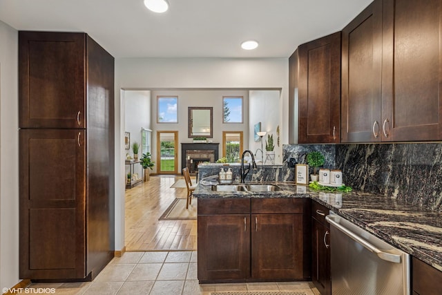 15733 Liberty Ct, Orland Park, IL 60462 - kitchen featuring stainless steel dishwasher, a sink, dark stone counters, a peninsula, and a brick fireplace