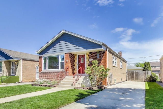bungalow-style home with brick siding, driveway, and a chimney